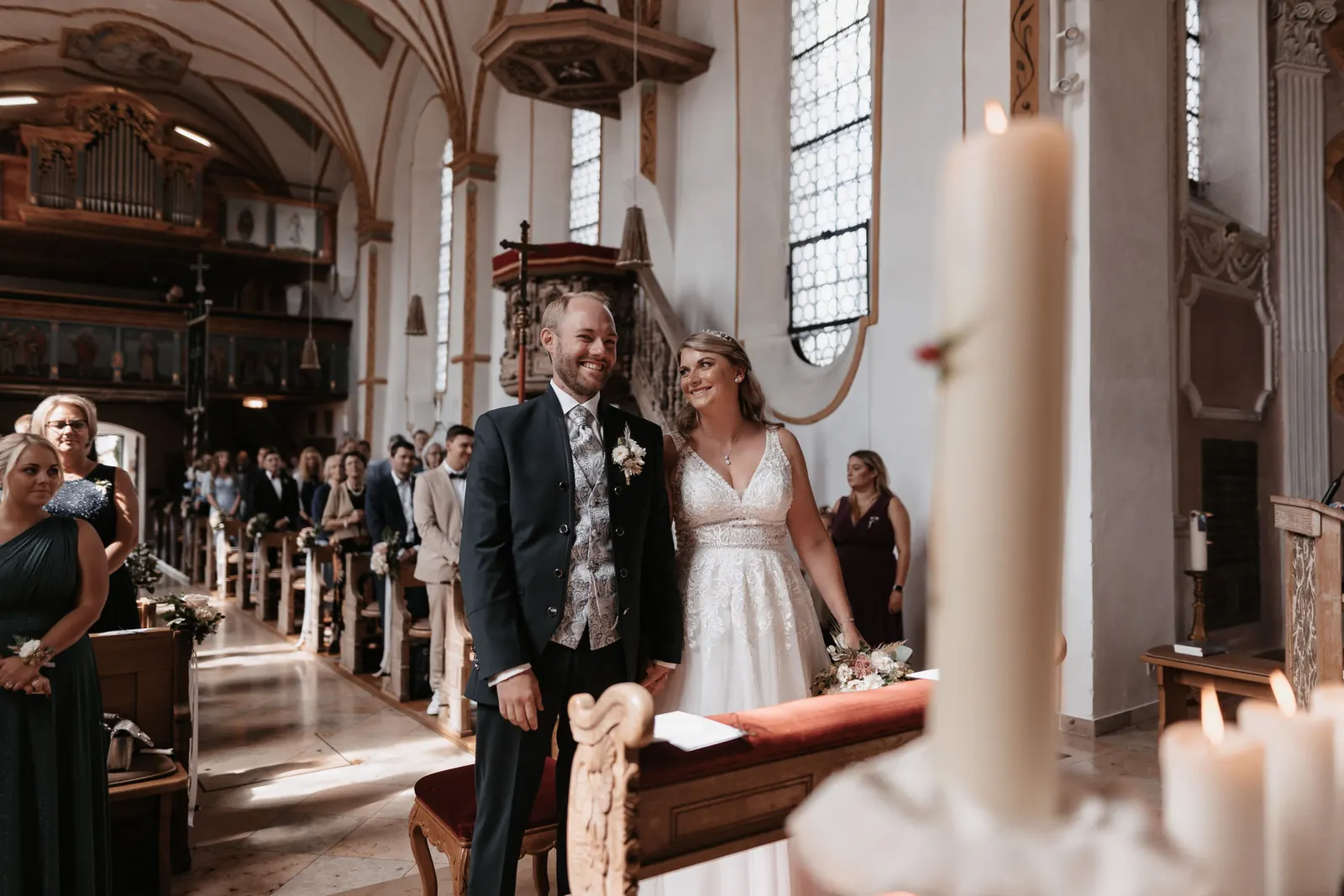Brautpaar lacht während der Trauung vor dem Altar der Kirche St. Andreas