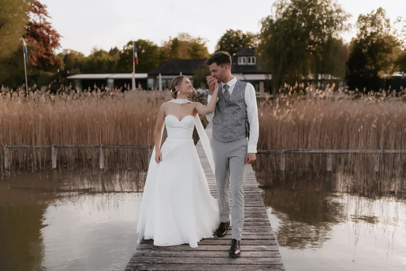 hochzeitsfotos ammersee brautpaar seehaus steg handkuss goldenstunde